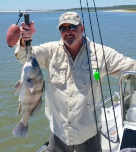 Carl and Andy catching reds. Carl is holding a black drum.