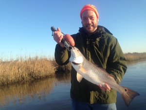 Dan Master with a nice redfish on a cold windy day with muddy water.