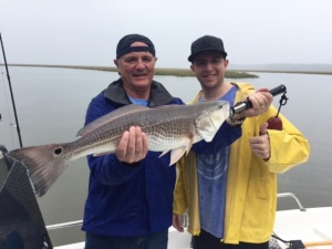 Larry Schmueser & John with a nice red! The guys caught a bunch or sea trout on a foggy/raining day.